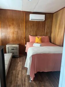 a bedroom with a bed with pink and yellow pillows at Small, Private Beach House & Pool in Vega Baja