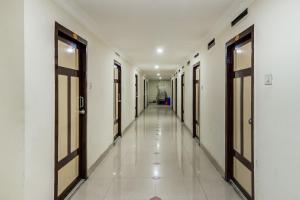 a corridor of a hospital with doors and tile floors at SPOT ON Swarna Mayuri in Guntūr