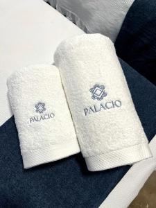 two white towels sitting on top of a chair at Apartamento Palacio céntrico y silencioso 4-8 personas in Granada