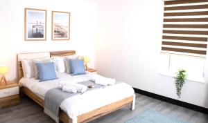 a bedroom with a bed with blue and white pillows at Manchester Apartments by BEVOLVE - Free Parking in Manchester