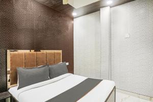 a bedroom with a bed and a wall at OYO Flagship 80575 Kashish Residency Near Model Town Metro Station in New Delhi