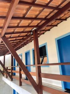 a wooden roof on a house with blue windows at Suite Grega 5- Centro da Vila Abrãao in Abraão