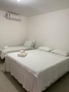 two twin beds in a room with a heater at Suite Grega 5- Centro da Vila Abrãao in Abraão
