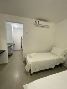 Habitación blanca con cama y pasillo en Suite Grega 5- Centro da Vila Abrãao, en Abraão