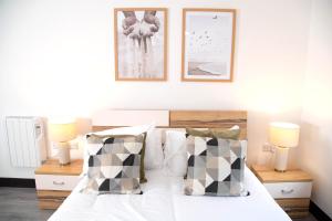 a bedroom with a bed with two lamps and two pictures on the wall at Manchester Apartments by BEVOLVE - Free Parking in Manchester
