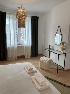 een witte kamer met een bed met twee handdoeken erop bij Cosy Alba plein centre Visé in Visé