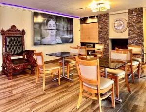 una sala da pranzo con tavoli, sedie e camino di Days Inn by Wyndham Southern Hills/ORU a Tulsa