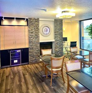 a dining room with tables and chairs and a fireplace at Days Inn by Wyndham Southern Hills/ORU in Tulsa