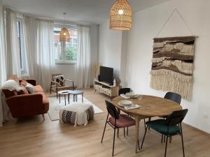 a living room with a person laying on a couch and a table at Cosy Alba plein centre Visé in Visé