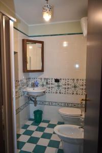 a bathroom with two toilets and a sink and a mirror at Casa vacanze Locus Amoenus in Sant'Agata de' Goti