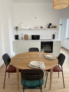 een eettafel met stoelen en een keuken bij Cosy Alba plein centre Visé in Visé