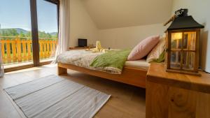Lič的住宿－Kuća za odmor Zeleni san，一间卧室设有一张床和一个大窗户