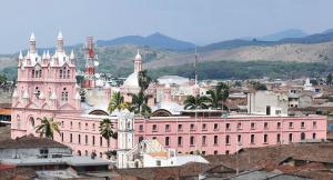 un grand bâtiment rose avec une tour d'horloge dans une ville dans l'établissement BUGA Casa Palermo Boutique Hotel, à Buga