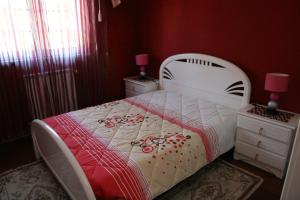 CarapitoにあるCasa da Pizzariaの白いベッドと赤い壁が備わるベッドルーム1室が備わります。