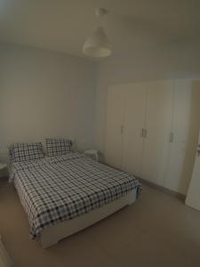 a bedroom with a bed with a checkered blanket at Waterside Apartments, El Gouna 1Bd plus Private Roof Terrace in Hurghada