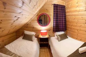 um quarto com duas camas num chalé de madeira em Chalé do Sossego Serra da Estrela em Cortes do Meio