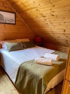 a bedroom with a bed in a wooden cabin at Chalé do Sossego Serra da Estrela in Cortes do Meio