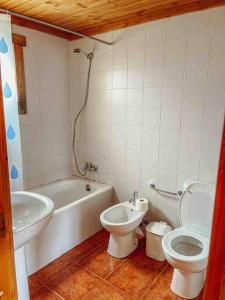a bathroom with a toilet and a tub and a sink at Chalé do Sossego Serra da Estrela in Cortes do Meio