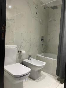 Baño blanco con aseo y lavamanos en Adrogué Apartments, zona céntrica de Adrogué en Adrogué