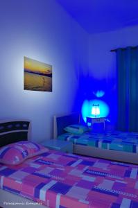 een slaapkamer met 2 bedden en een blauw licht bij Garden house in Amarinthos
