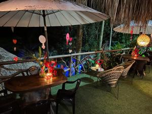 a patio with tables and chairs and an umbrella at Monte Verde Hostal in El Zaino