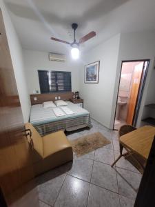 a bedroom with a bed and a ceiling fan at Hotel Graunas in São Carlos