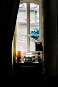 a table with two lamps and a window at La Maison de Laulie in Bagnères-de-Bigorre