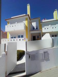 Biały budynek z bramą przed nim w obiekcie Merci Beach House w mieście Carvoeira