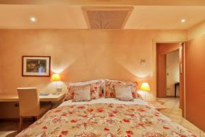 a bedroom with a large bed with a desk and a desk at Cernobbio lake suites in Cernobbio +61 photos