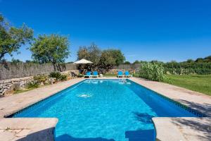 una piscina con sillas azules en un patio en Can Nin en Santanyi