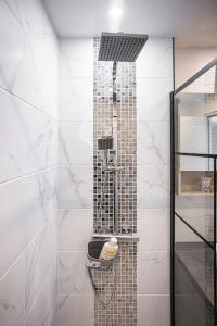 La salle de bains est pourvue d'une douche et de carrelage blanc. dans l'établissement La Casa de la Smala, à Pau