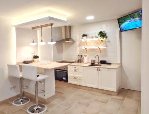 - une cuisine avec des placards blancs et un évier dans l'établissement Apartamento en el casco historico de Betanzos, à Betanzos