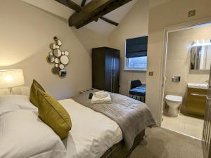 a bedroom with a bed and a bathroom with a toilet at The Barbican in York