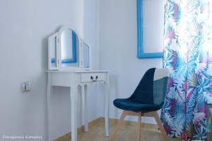 een kamer met een blauwe stoel en een spiegel bij Garden house in Amarinthos