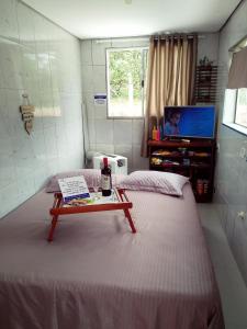um pequeno quarto com uma cama com uma mesa em Chácara Volare em Atibaia, exclusiva, condomínio fechado em Atibaia