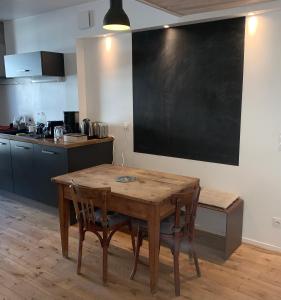 een keuken met een houten tafel en een schoolbord aan de muur bij Appartement cosy in Lyon