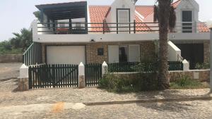 una casa con una valla delante de ella en Beach Townhouse - Murdeira Village en Beirona