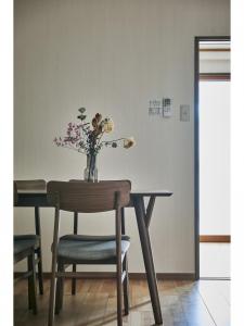 a dining room table with a vase of flowers on it at Kyoto Hostel family room / Vacation STAY 8181 in Nishinotōindōri