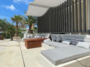 a patio with a couch and an umbrella at VILLA TIEGO in Medulin