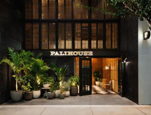 an entrance to a palazzo building with potted plants at Palihouse Hyde Park Village in Tampa