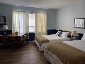 pokój hotelowy z 2 łóżkami, stołem i oknem w obiekcie Royal Hotel Chilliwack w mieście Chilliwack