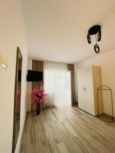 una sala de estar con un jarrón de flores en un suelo de madera en Apartament CHIC, en Vatra Dornei