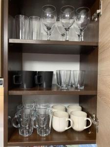 a cupboard filled with glasses and coffee cups at Apartament ,, Sen i Kawa'' - komfortowy nocleg w sercu aglomeracji in Bytom