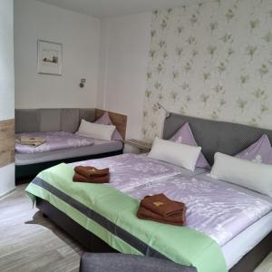 Dos camas en una habitación con toallas. en Pension Elisabeth am Elberadweg en Prödel