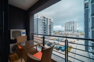 balcón con mesa, sillas y vistas a la ciudad en Luxurious 3 Bedroom Apartment at Victoria Island en Lagos