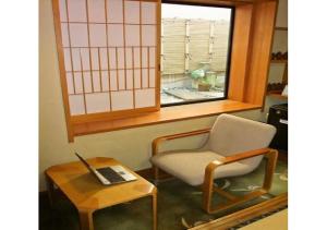 um quarto com uma cadeira e uma mesa com um computador portátil em Wakaba Ryokan / Vacation STAY 29370 em Sakata