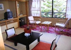 uma sala de estar com uma mesa e cadeiras e uma televisão em Wakaba Ryokan / Vacation STAY 29370 em Sakata