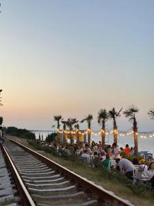 a group of people sitting next to a train track at Lenkeran Seaside in Lankaran