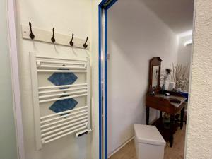 a bathroom with a toilet and a towel rack on the door at 1912 - Blue Room - old town in Locarno +16 photos