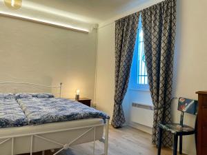 ein Schlafzimmer mit einem Bett und einem blauen Fenster in der Unterkunft 1912 - Blue Room - old town in Locarno